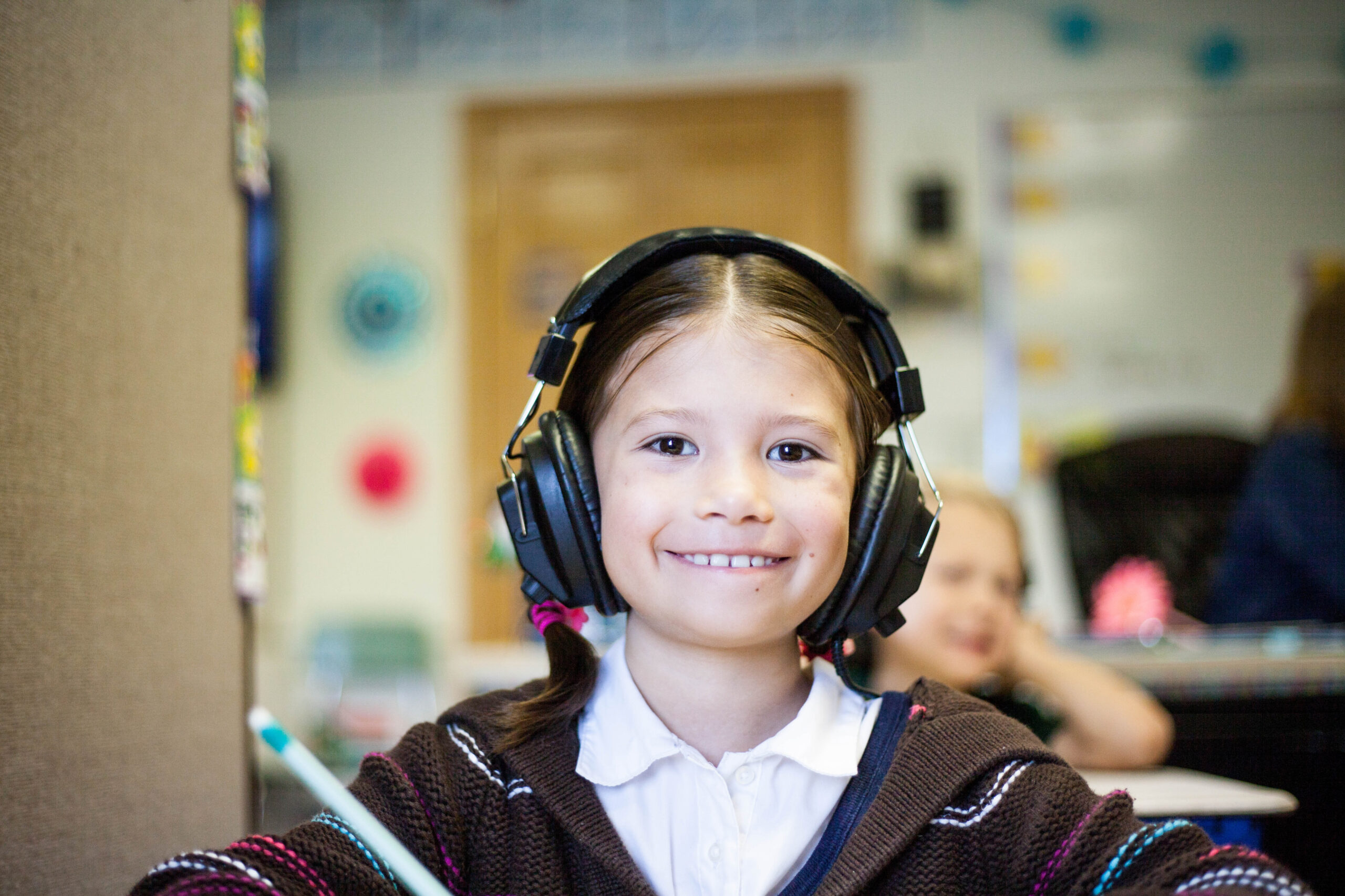 Young girl in school with headphones on