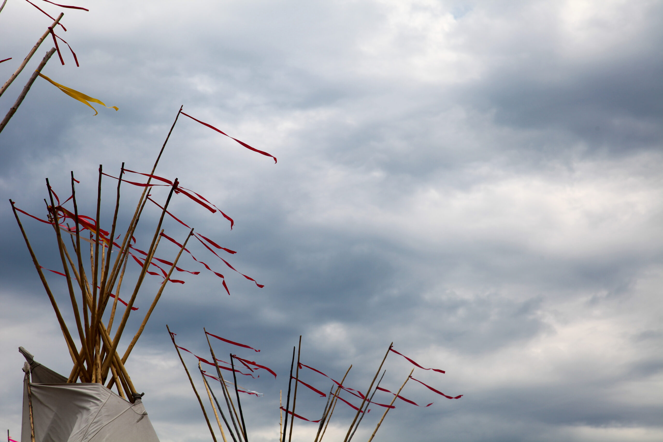 Tops of teepees with ribbons flowing in the wind