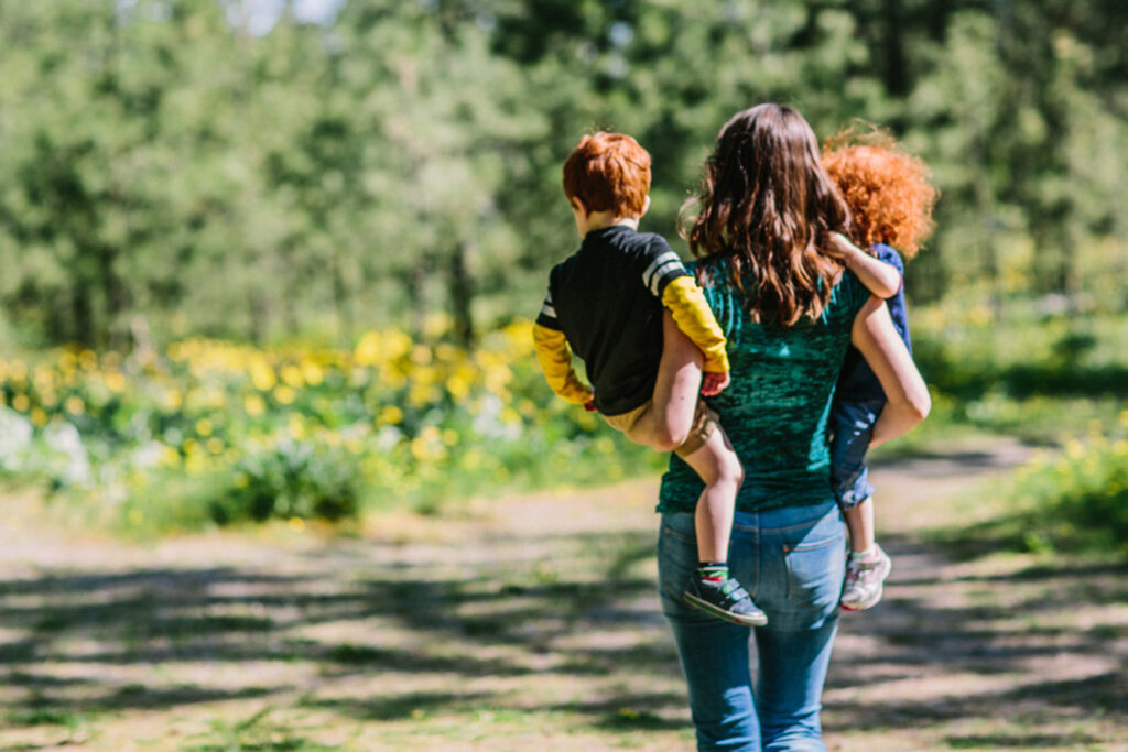 a woman holds two small children