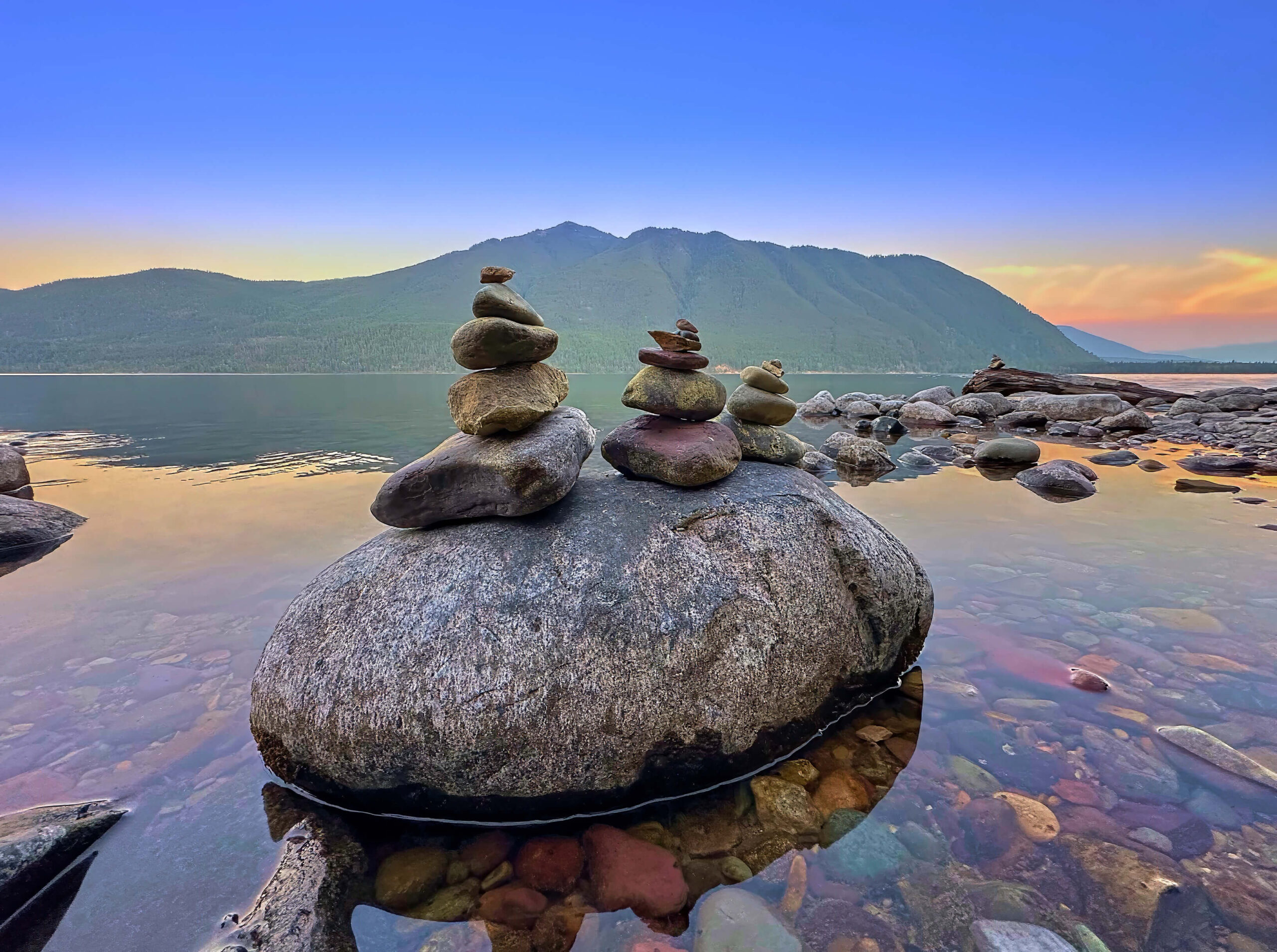 Karen rock formations on top of a larger rock on the shore of a lake with a mountain in the background - image used to discuss the transparency of our work