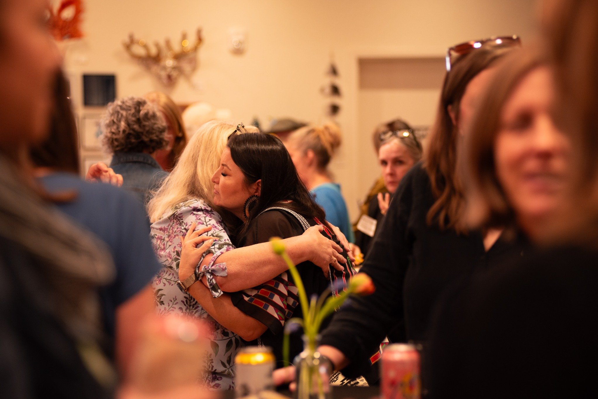 Two women hug in a crowd